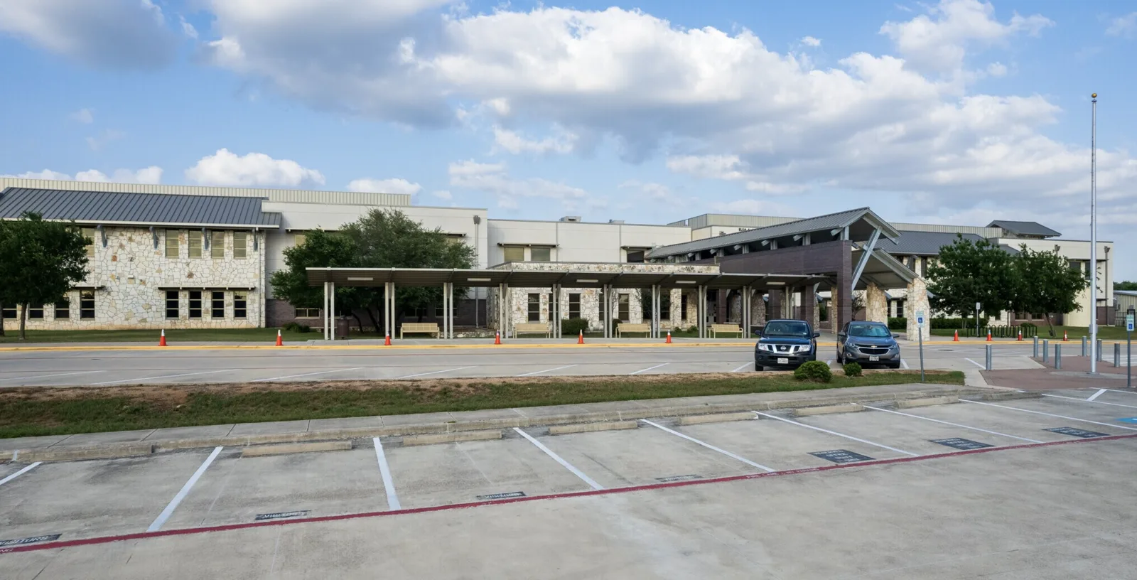 The front entrance of an Avery Ranch elementary school with a stone-faced building and covered walkway