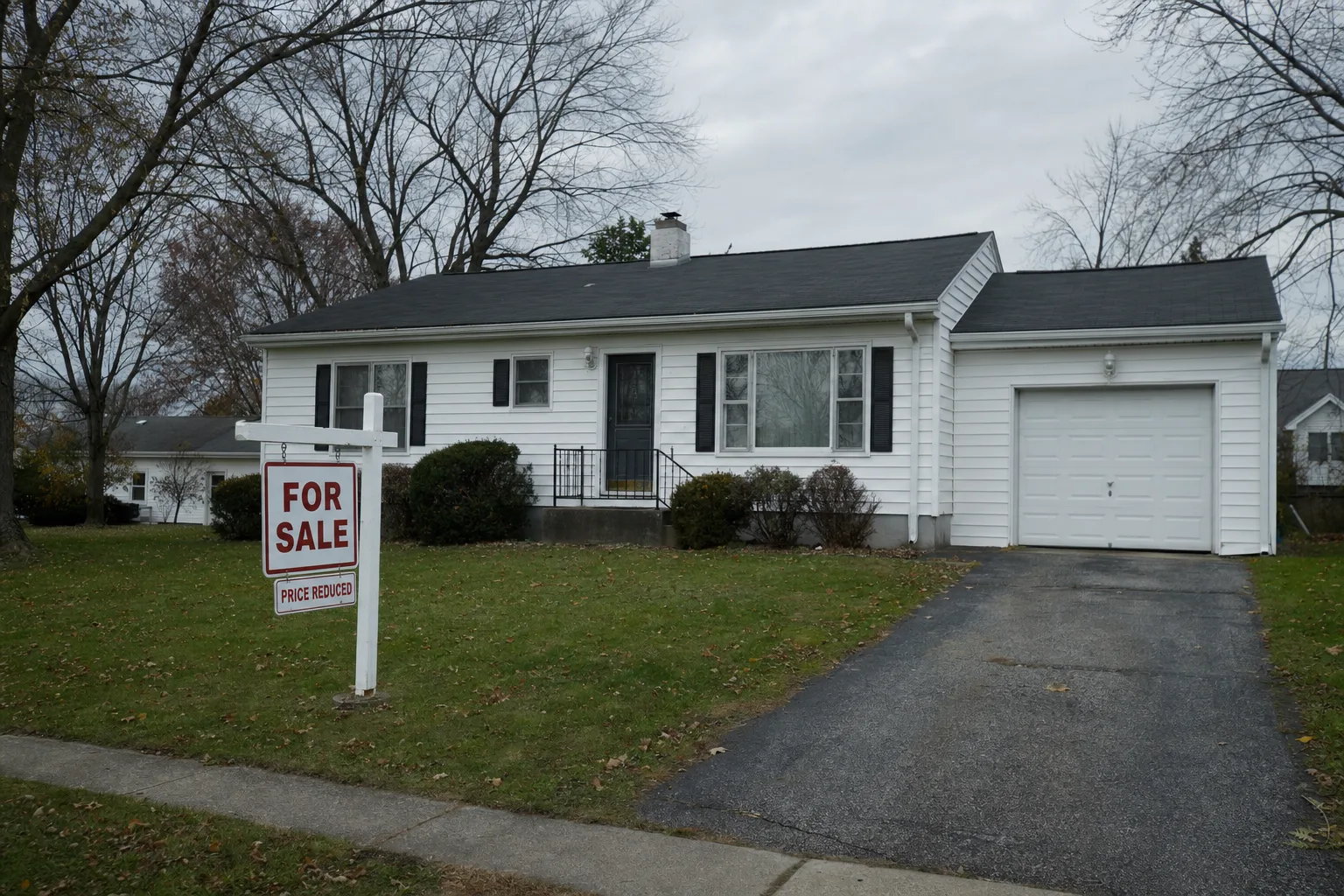 A suburban home with a for-sale sign in the yard