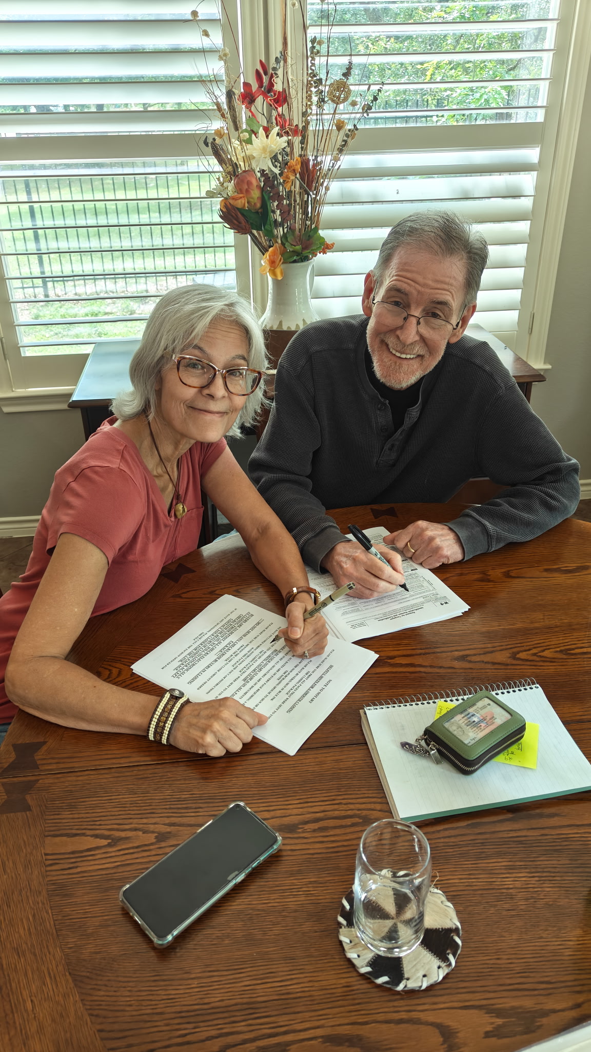 Roxanne and Brian signing paperwork at their dining table in Georgetown